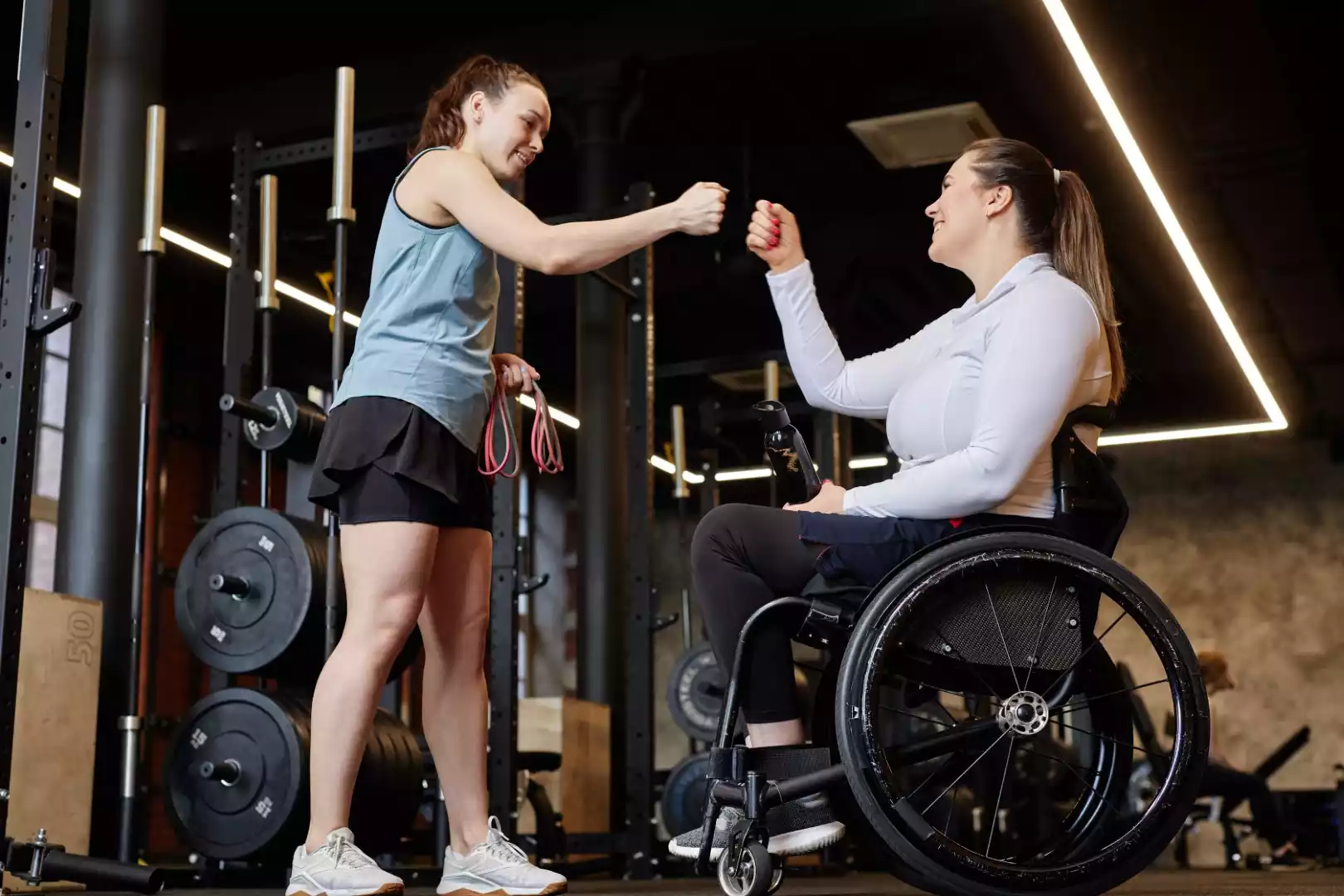 fitness-coach-fist-bump-with-woman-with-disability-2024-08-02-16-38-36-utc (Large)